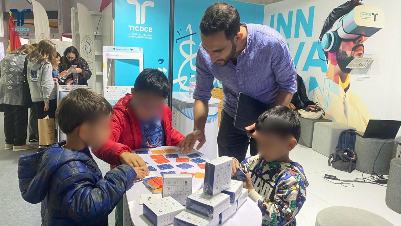 Familles et enfants réunis autour d'un jeu ECUME lors d'un événement public