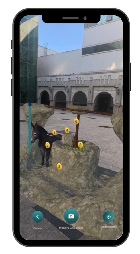 Smartphone affichant la reconstitution en réalité augmentée d'une huilerie troglodyte
